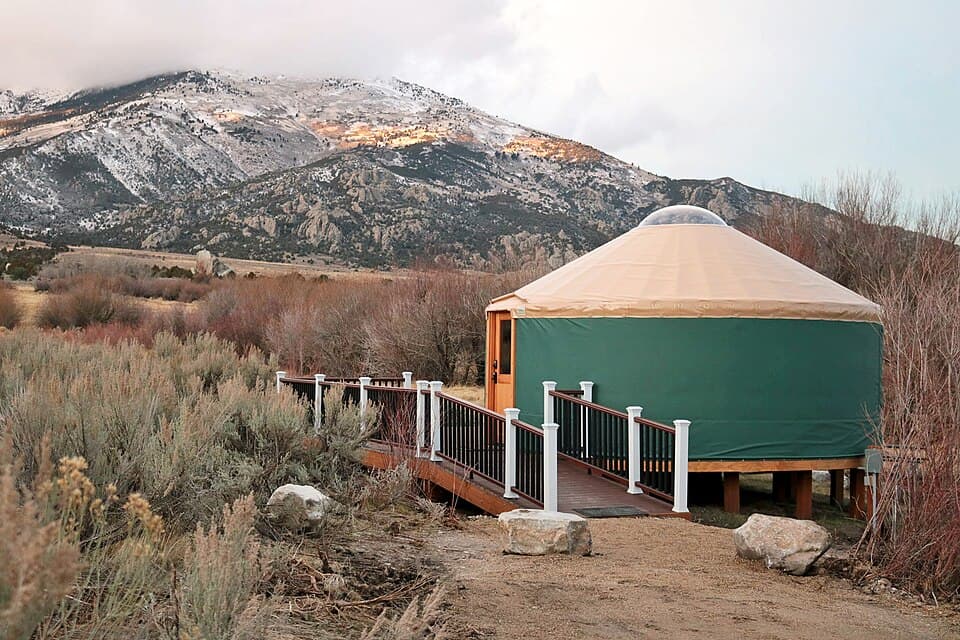 Glamping yurt with a mountain backdrop at dusk