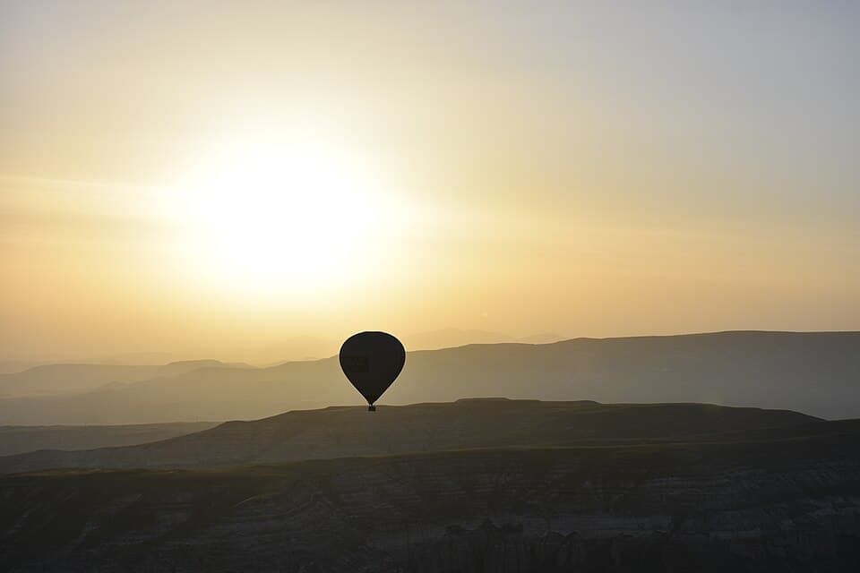 Hot air balloon at sunrise over the Cappadocia landscape